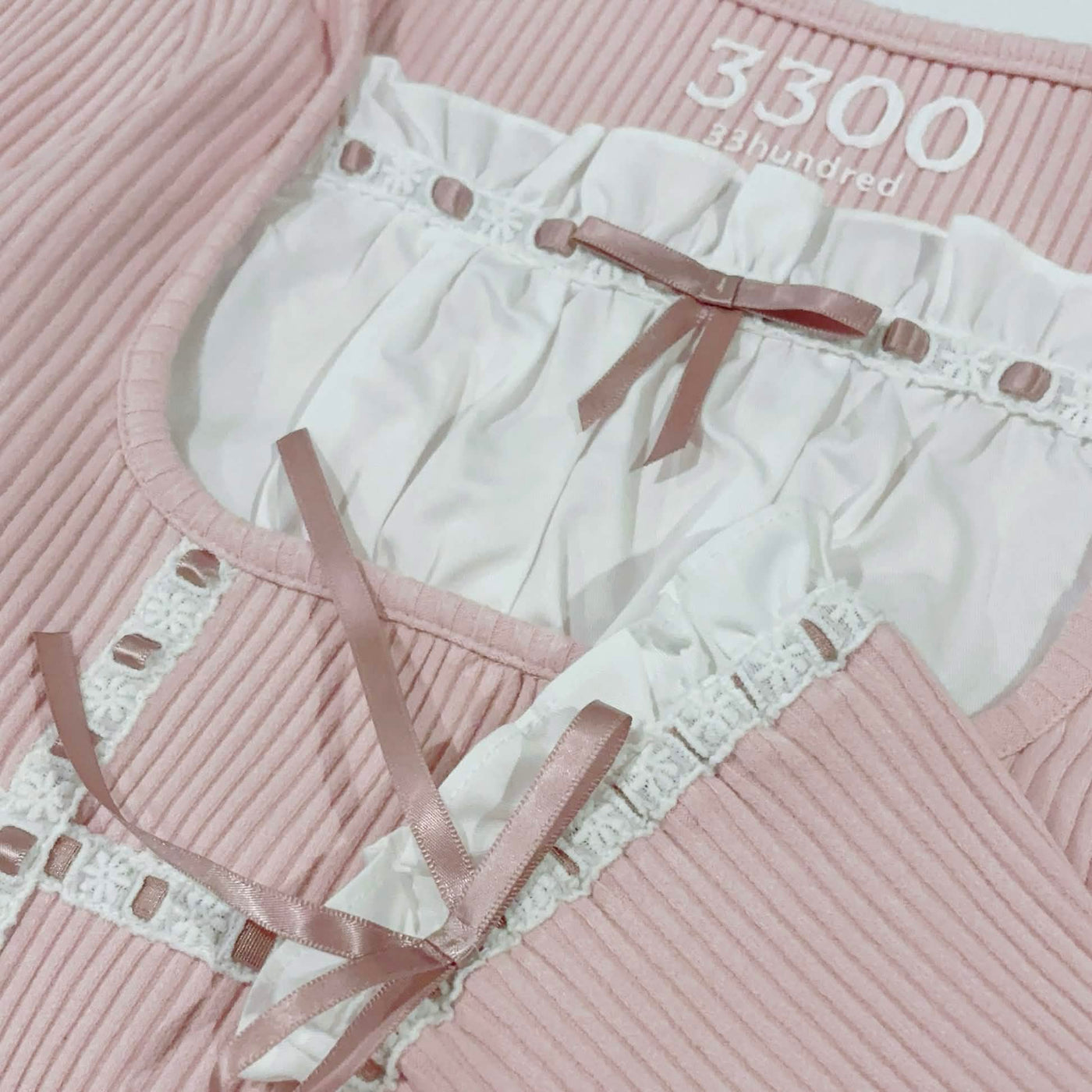 Pink johnny blouse neckline, trim, and straps laid flat